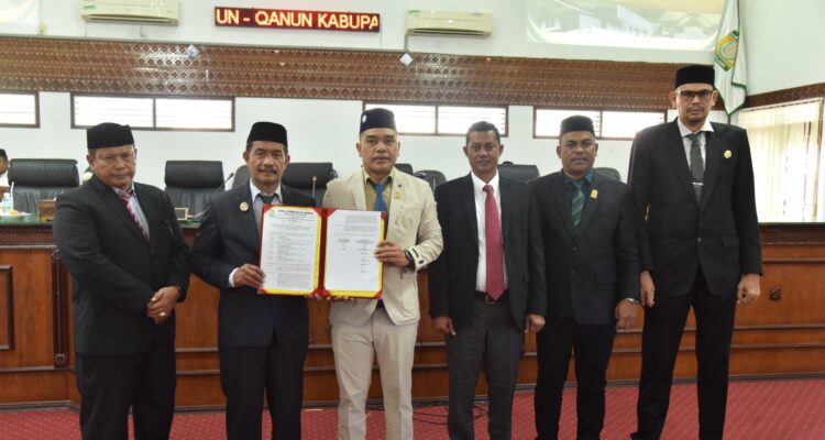 Wakil Bupati Aceh Besar Drs H Syukri didampingi Sekdakab Aceh Besar Bahrul Jamil SSos MSi foto bersama Ketua DPRK Abdul Muchti dan para Wakil Ketua DPRK Aceh Besar serta Sekretaris DPRK Aceh Besar seusai menyampaikan jawaban atas pemandangan umum Fraksi-fraksi DPRK Aceh Besar tentang Rancangan Qanun Penyertaan Modal Daerah Kabupaten Aceh Besar pada Perusahaan Umum Daerah Air Minum Tirta Mountala Kabupaten Aceh Besar di Gedung DPRK Aceh Besar, Selasa (19/5/2026). FOTO/ MC ACEH BESAR